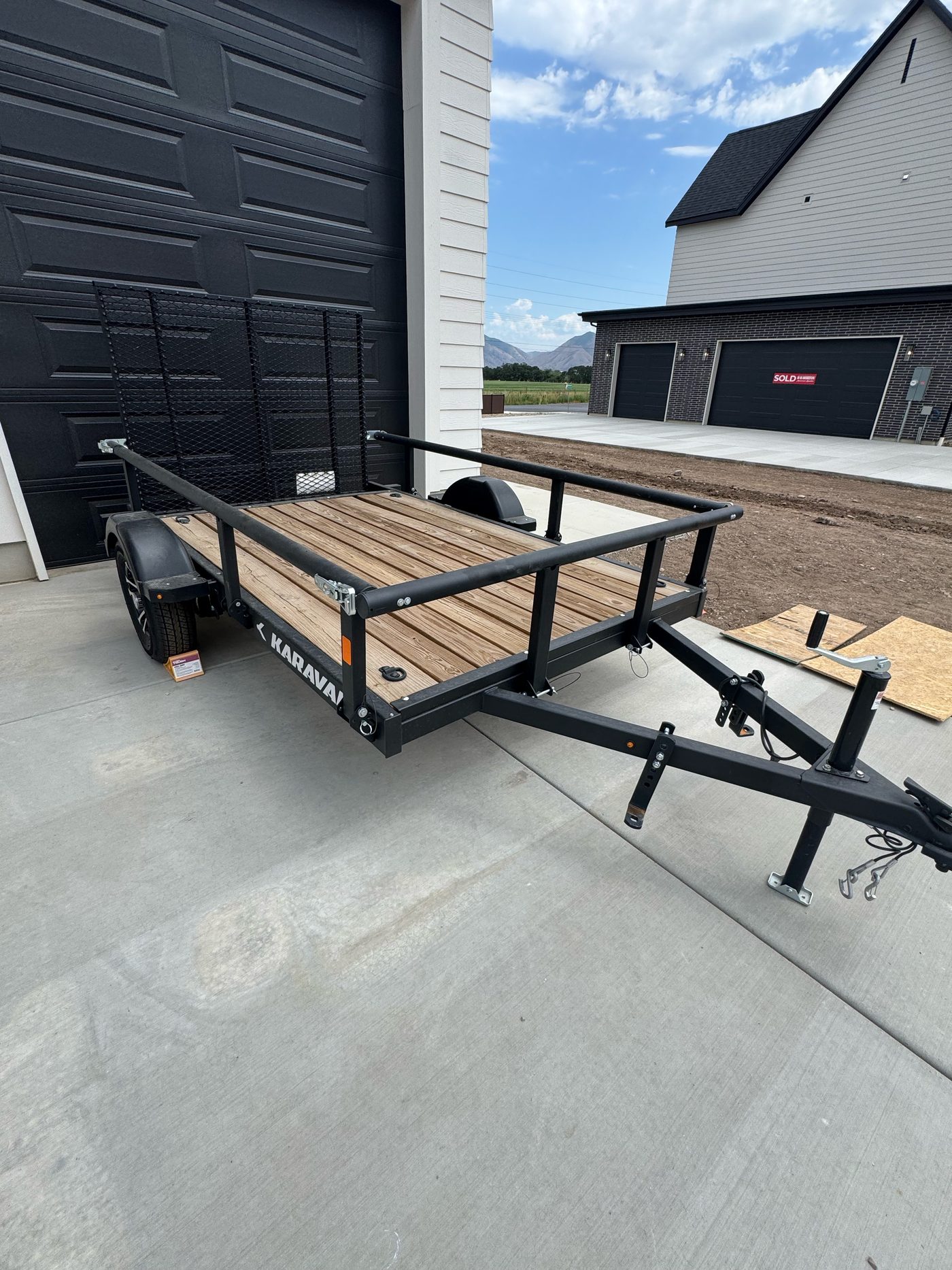 Full view of the 2026 Karavan 5.5x10 utility trailer with rails, tongue, wheel and ramp gate
